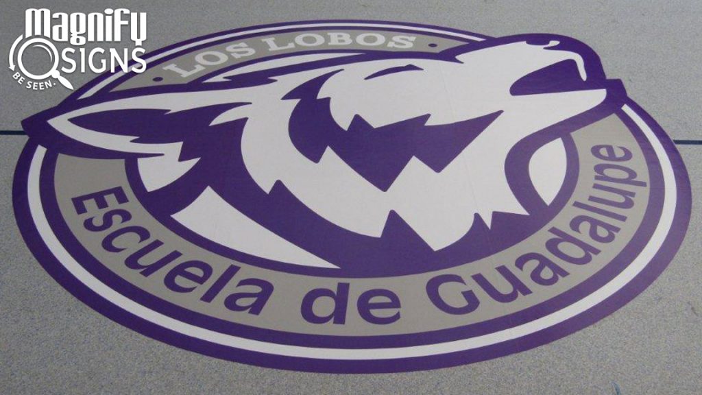 Custom Circular Vinyl Print of the "Los Lobos" placed on the gym floor or Escuela de Guadalupe school in Denver, CO