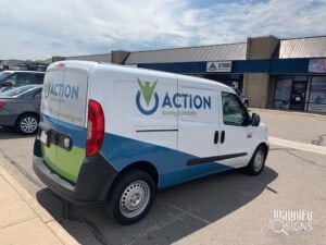 A white van with Action Seating & Mobility branding and logo is parked in front of a row of commercial buildings on a sunny day. The van has colorful blue and green accents and company contact details.