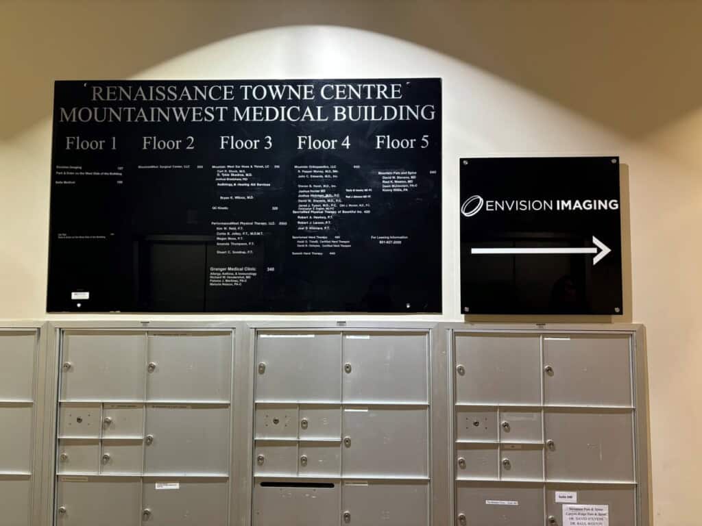 Wall directory at Renaissance Towne Centre Mountainwest Medical Building, listing floor occupants above rows of mailboxes; a sign to the right points to Envision Imaging with a right arrow.