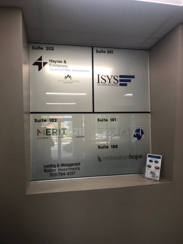 A wall directory lists businesses in suites 100–202, including Haynie & Company, ISYS Technologies, Merit 2B, Trillian, and Restoration Hope. Leasing info and a brochure holder are at the bottom.