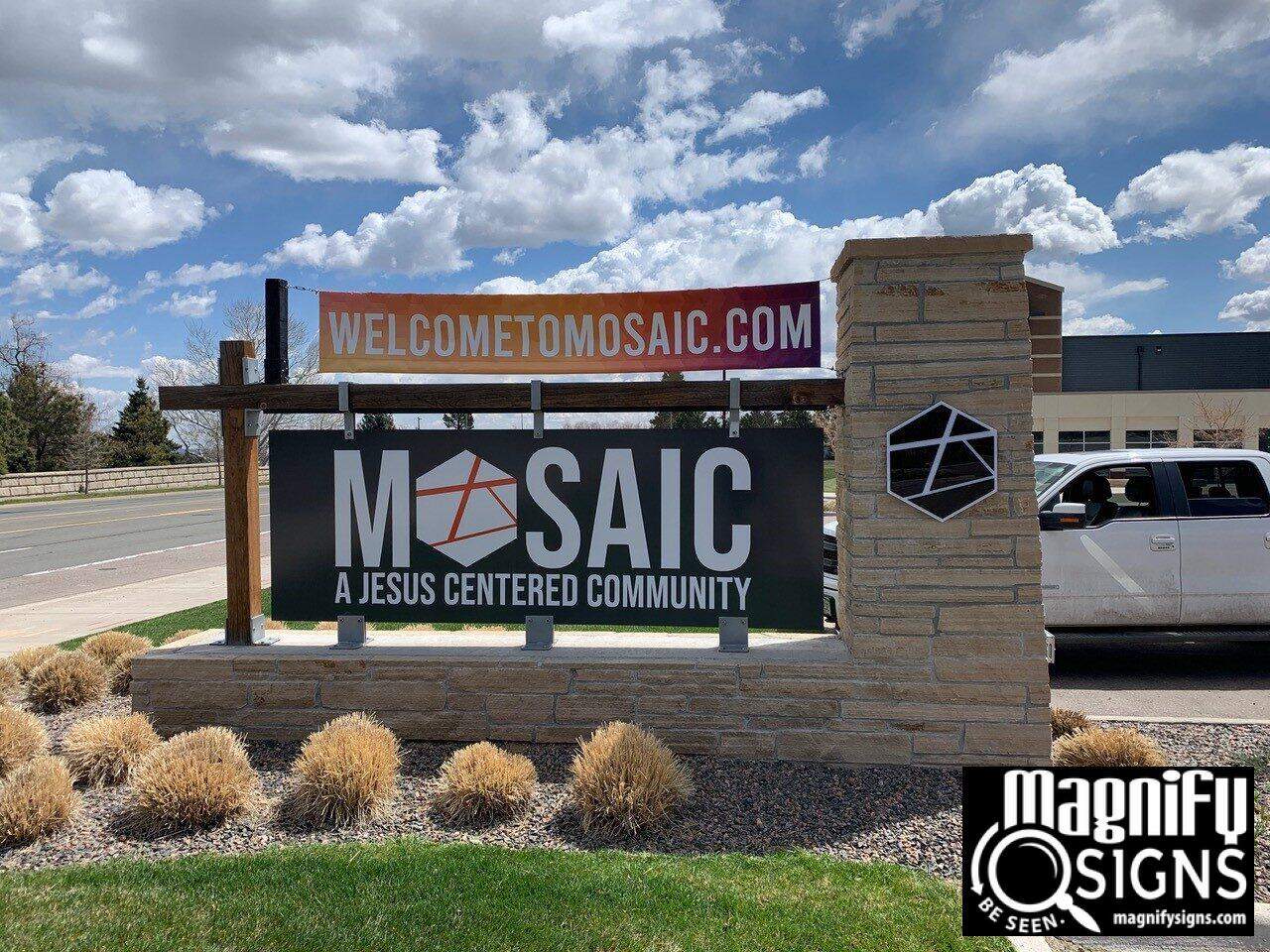 A large outdoor sign reads “MOSAIC: A JESUS CENTERED COMMUNITY” with a geometric logo. Above it hangs an orange banner, “WELCOMETOMOSAIC.COM.” The Magnify Signs logo is in the bottom right corner.